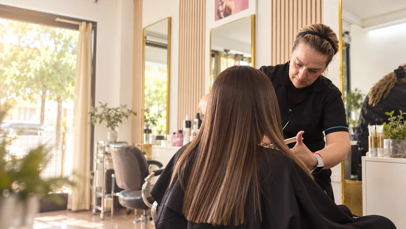 Profesional atendiendo a una clienta en un salón de peluquería